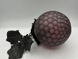 a purple glass ball with a leaf on top of it