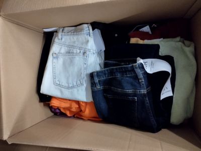 une boîte en carton remplie de vêtements et d'une paire de chaussures