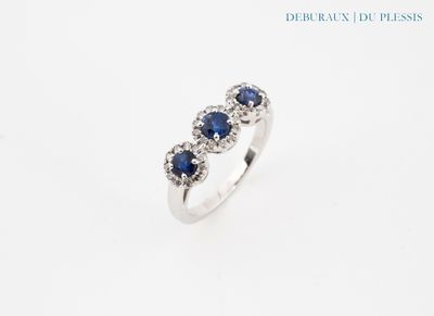 un gros plan d'une bague sertie de trois saphirs