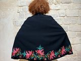 woman wearing a black shawl with pink and green flowers on it