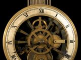 a gold clock with a black face on a black background