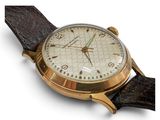 a close up of a watch on a white surface