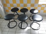 four stools sitting on a tiled floor in a room