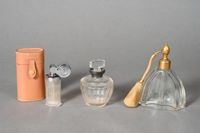 three bottles of perfume and a case on the table