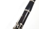 a black and silver clarinet that is on a white surface