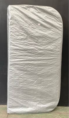 un matelas emballé, posé par terre