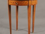 une petite table ronde avec un plateau en verre et des pieds en bois