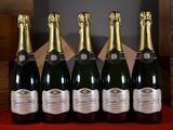 six bottles of champagne are lined up in a row on a table