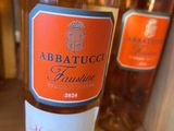 une bouteille de vin posée sur une table, à côté de deux autres bouteilles de vin