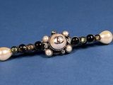 a close up of a beaded bracelet with pearls on it