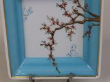 une assiette bleue et blanche ornée de fleurs rouges