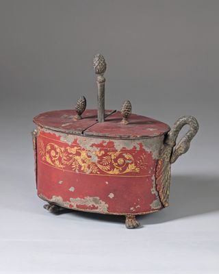 an old red and gold covered box with two birds on it