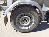 a truck with a trailer attached to it parked on the street