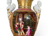 a gold vase with a picture of a man and a woman on it
