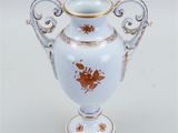 a white vase with a gold decoration on it