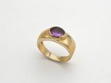 une bague en or sertie d'une pierre violette