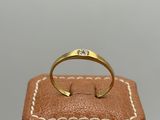 a gold ring sitting on top of a brown leather box