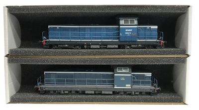 deux trains bleus posés dans une boîte sur les rails
