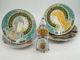 une petite figurine posée à côté d'une assiette sur laquelle figure une image