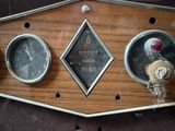 three gauges on the side of a wooden panel