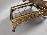 a gold piano that is sitting on a white table