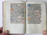 someone is holding an open book in their hands on a white surface