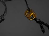 une photo en noir et blanc d'un collier orné d'un pendentif en or