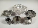 several pieces of silverware are arranged on a white surface