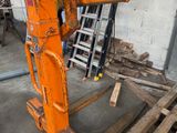 une grande machine orange qui se trouve dans un entrepôt