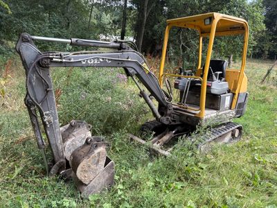 a small excavator that is sitting in the grass