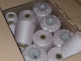 many rolls of white yarn in a cardboard box