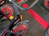 a lot of stationary bikes in a gym room