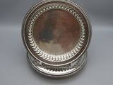 a pair of silverplated plates with beading around the edges