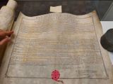 an old document with a wax stamp on it sitting on a table