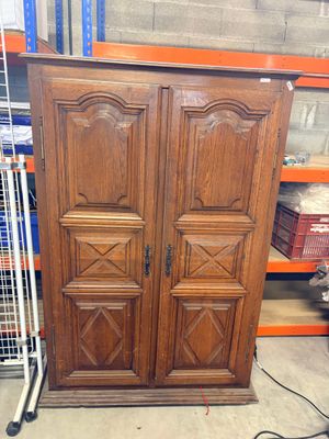 une grande armoire en bois dans un magasin où se trouvent de nombreux autres articles