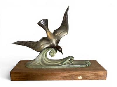 sculpture représentant un oiseau sur une vague, posée sur un socle en bois