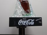 a bottle of coke sitting on top of a black table