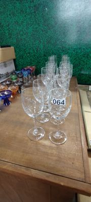 Plusieurs verres à vin vides sont posés sur une table devant un mur vert.