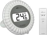 a white alarm clock with a remote control next to it
