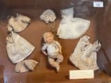 a display case with a doll in it and other items in it