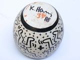 a white vase with black writing on it on a white surface