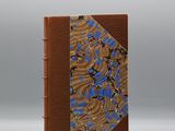 un livre marron orné d'un motif bleu et marron