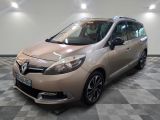 La voiture beige est garée sur le sol à damier du garage.