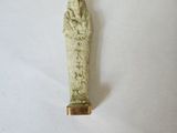une image représentant une petite statue d'une personne avec une main posée sur la tête