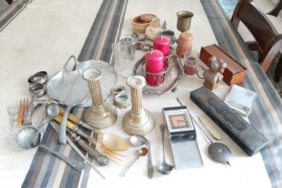 une table sur laquelle sont disposés de nombreux couverts et autres objets
