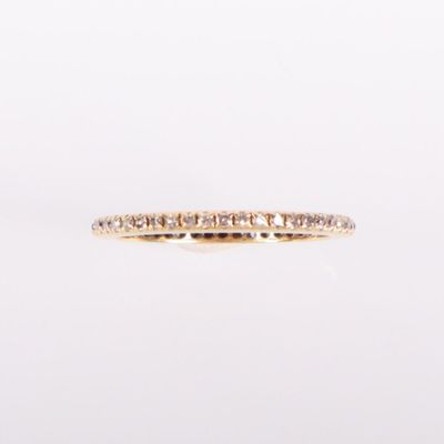 une alliance en or jaune sertie de diamants blancs sur fond blanc