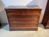a wooden chest of drawers with a marble top