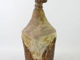 brown and white vase with a wooden top on a white surface