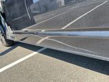 a silver van parked in a parking lot with its door open