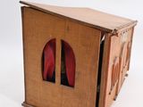 a small wooden box with a pair of red shoes inside of it
